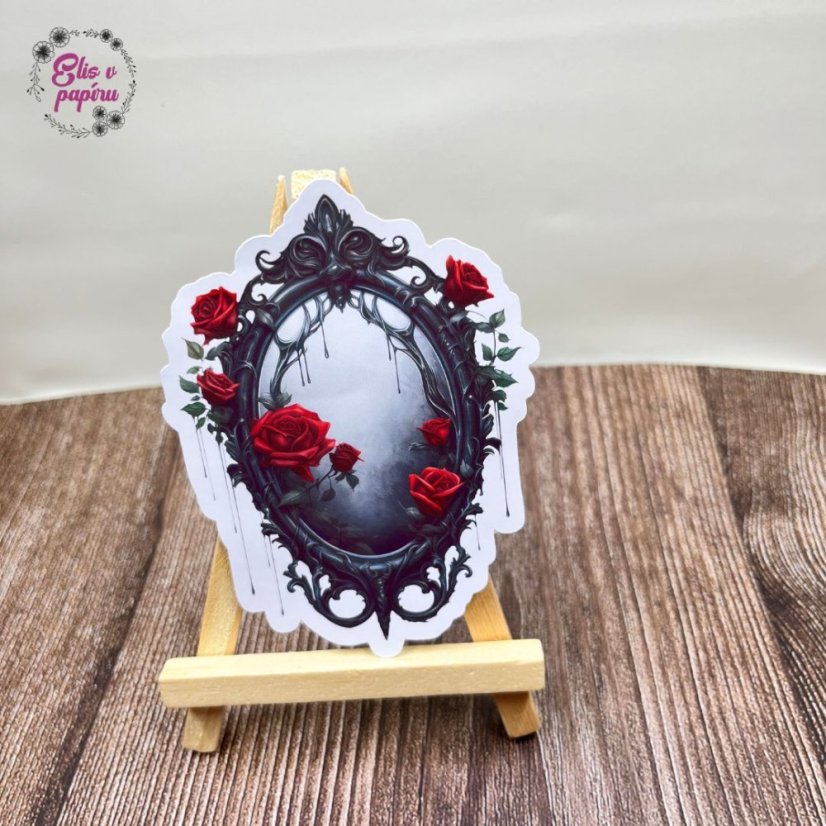 Gotické zrcadlo zdobené černými ornamenty, z něhož kapou tmavé stíny. Okolo něj jsou rozesety červené růže, které přidávají dramatický kontrast.