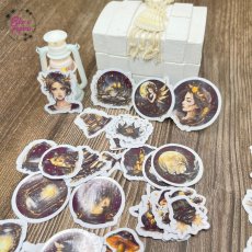 Detailní samolepky s kouzelnými motivy víl, lahviček se světýlky, zlatavými hvězdami a magickými houbami, vše laděné do zlatavých a temně nočních tónů.