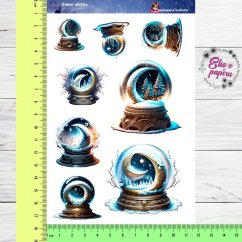 Magické skleněné koule se zimními motivy, zasněžené krajiny a noční obloha.